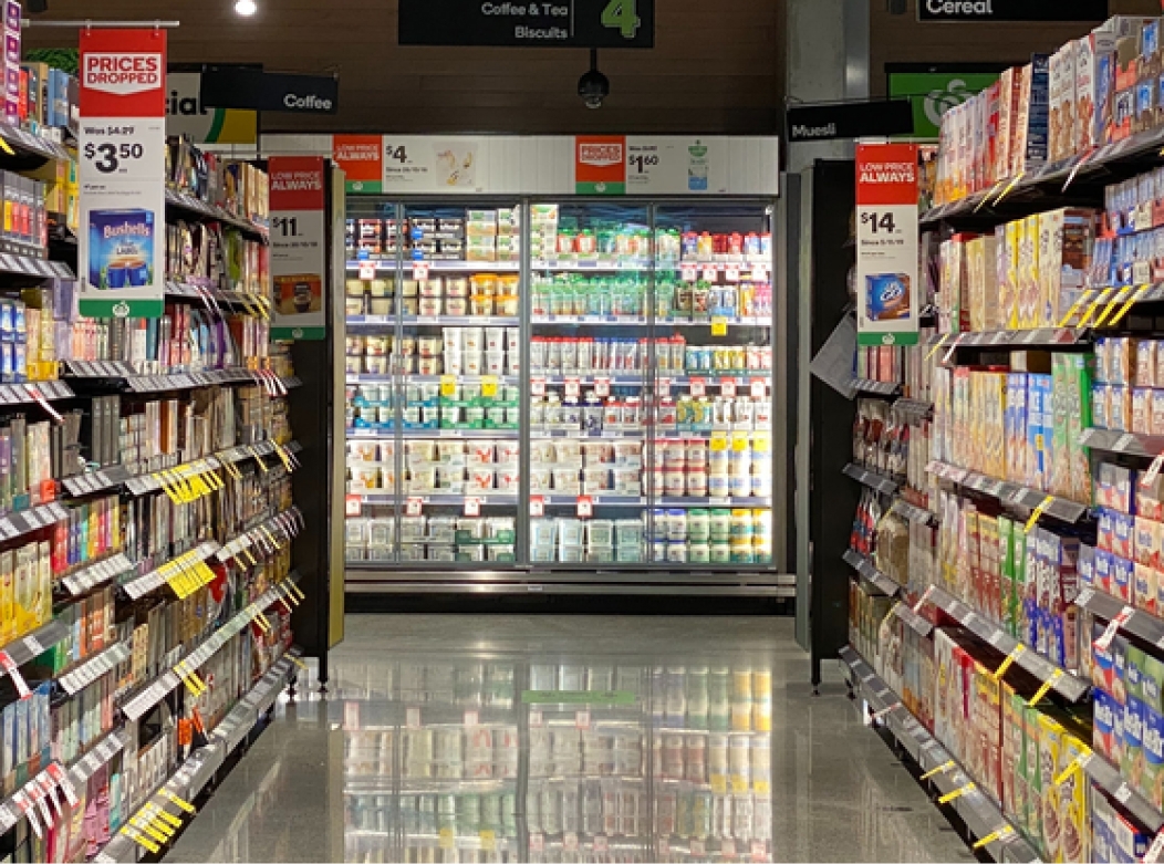 An aisle in a grocery store, displaying many packaged products.
